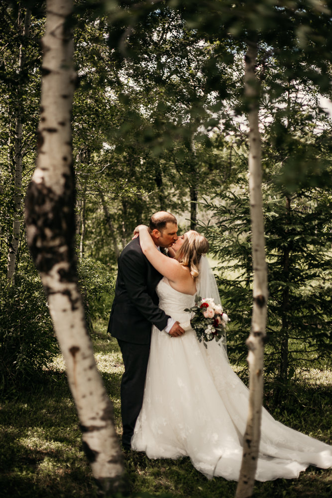 bride and groom kissing in forest