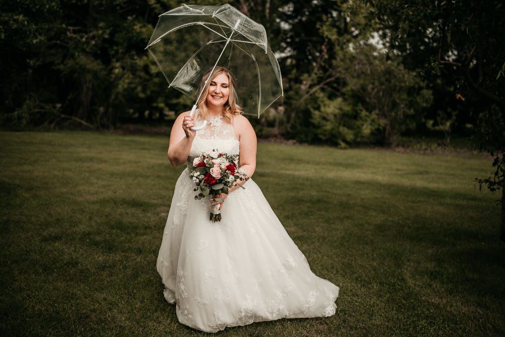 bride holding umbrella and bouquet