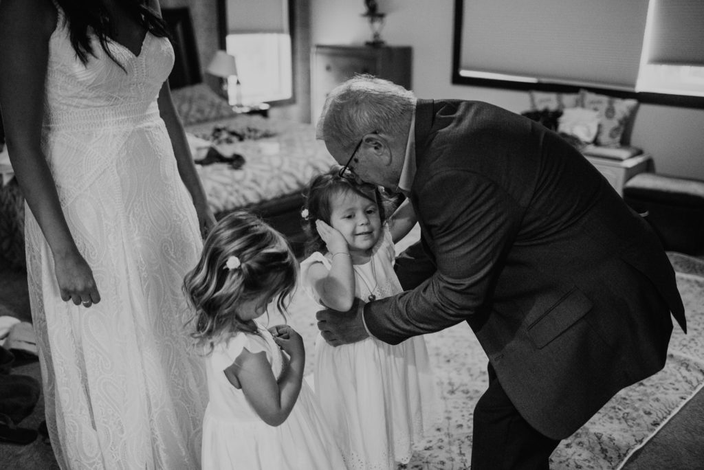 flower girl spends moment with grandfather before wedding ceremony