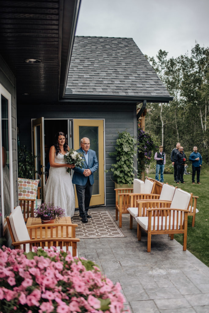 bride with father entering backyard wedding ceremony