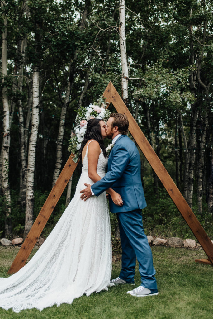 bride and groom's first kiss at backyard wedding ceremony